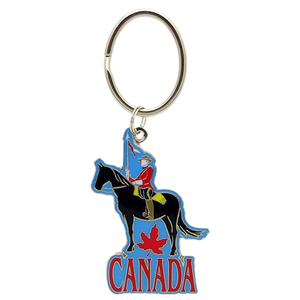 A decorative keychain featuring a detailed figurine of a Canadian RCMP Mountie riding a horse, serving as a unique and patriotic souvenir from Canada